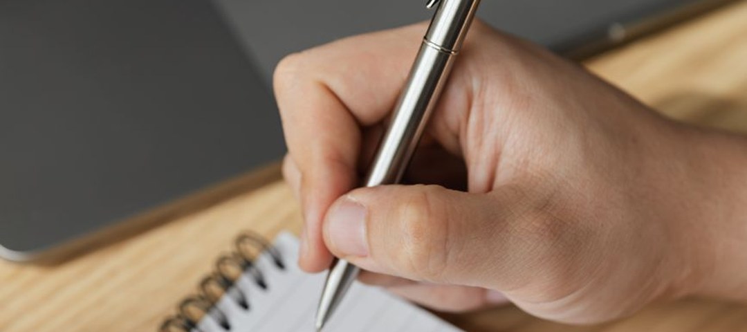 Carnet de notes et ordinateur pendant une consultation à distance — le bilan de vitalité en naturopathie Carnet de notes et ordinateur pendant une consultation à distance — le bilan de vitalité en naturopathie